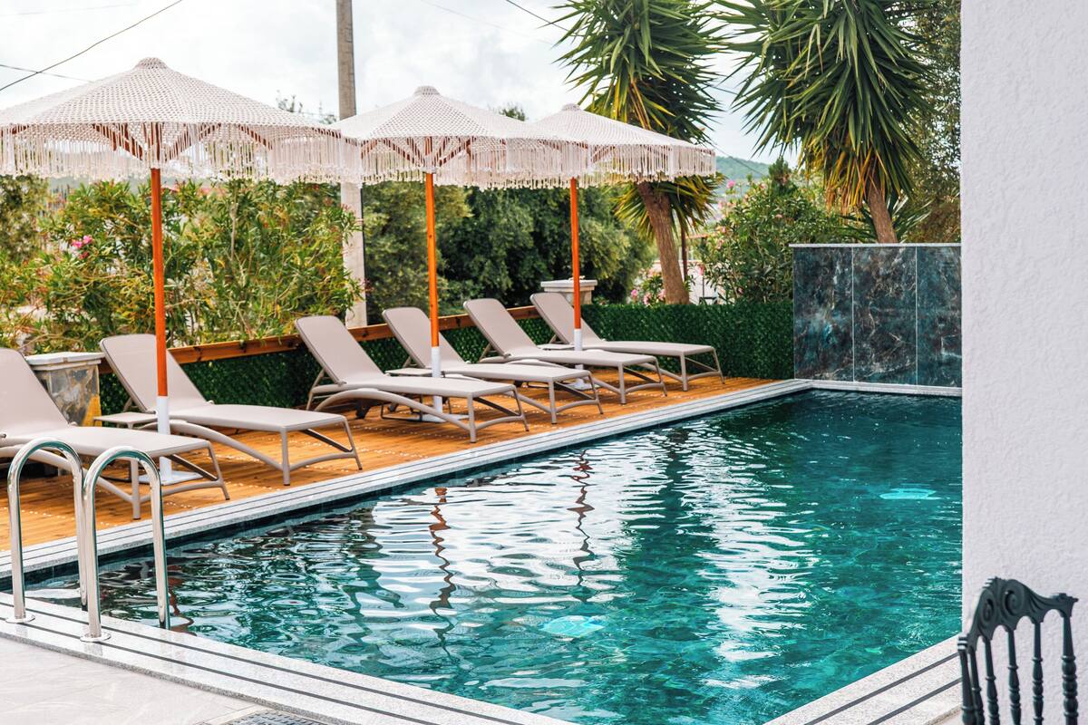 A swimming pool with lounge chairs and umbrellas.