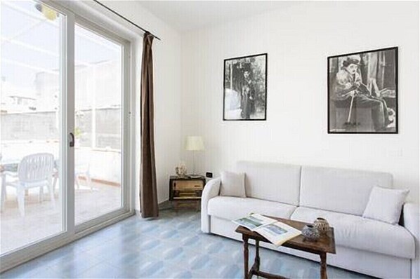 Ein Wohnzimmer mit einem weißen Sofa, einem Couchtisch und zwei gerahmten Bildern an der Wand.
