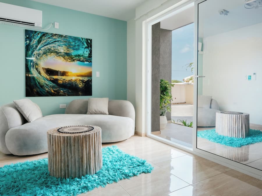 Un salon moderne avec un canapé, une table basse ronde en bois et un grand tableau abstrait accroché au mur.