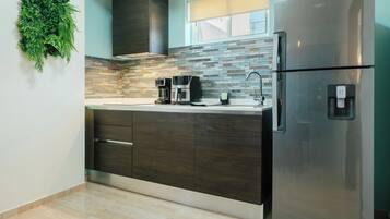 Una cocina moderna con un refrigerador de acero inoxidable, armarios de madera oscura, salpicadero de azulejos y un jardín de hierbas integrado.