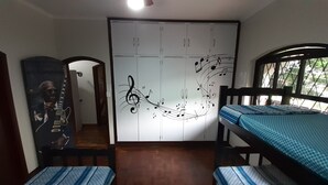 Un dormitorio con un armario, una cama y un póster en la pared.