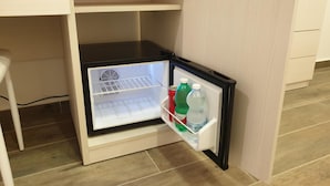 A compact refrigerator with a freezer compartment, placed under a kitchen counter. - Giò Rooms (Scalea)