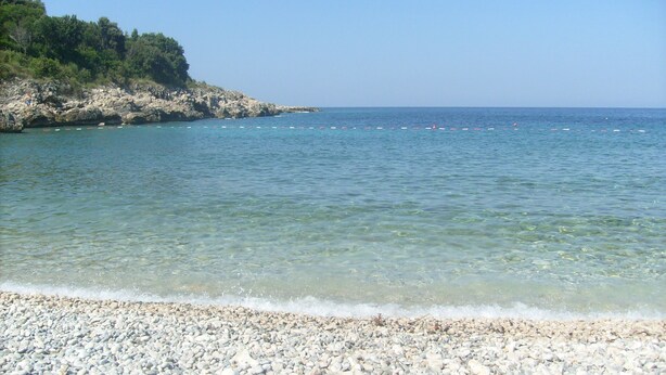 A pebble beach with clear water and a rocky coastline. - Majero Apartments (Utjeha)