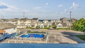 Un quartier résidentiel avec une piscine, des maisons et un ciel dégagé.
