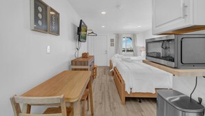 Une chambre à coucher avec un lit, une table de chevet et un téléviseur fixé au mur.