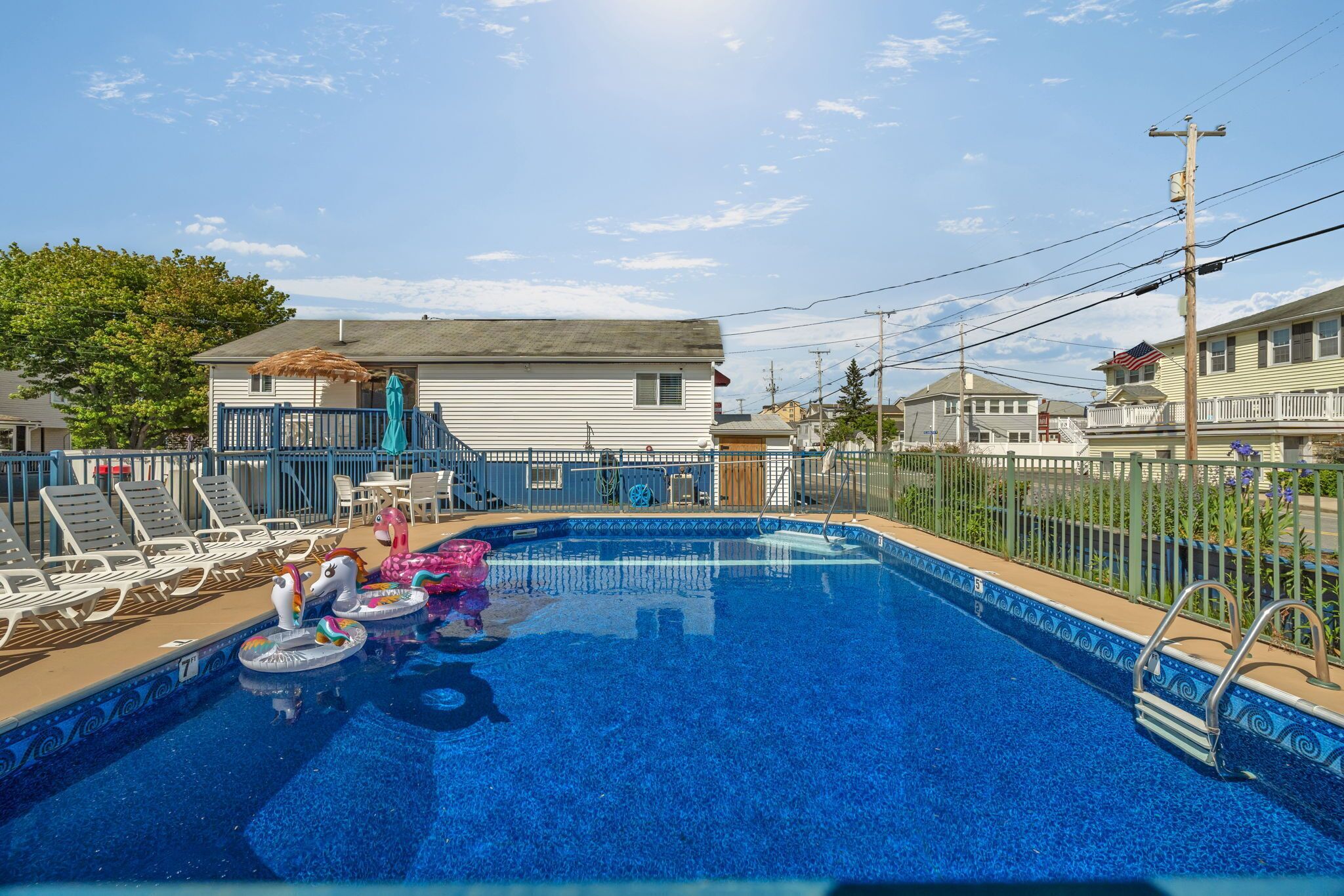 Una piscina al aire libre de temporada, sombrillas