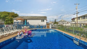 Una piscina al aire libre de temporada, sombrillas