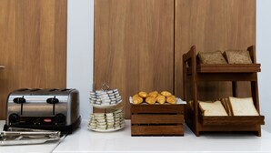 A kitchen counter with a toaster, a stack of eggs, a tray of croissants, and a bread rack. - Holiday Inn Express Shanghai Tangzhen by IHG (Shanghai)