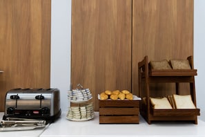 A kitchen counter with a toaster, a stack of eggs, a tray of croissants, and a bread rack. - Holiday Inn Express Shanghai Tangzhen by IHG (Shanghai)