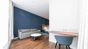 A modern living room with a grey sofa, a round coffee table, and a blue chair. - Holiday Inn Express Shanghai Tangzhen by IHG (Shanghai)