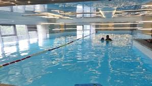 An indoor swimming pool with clear water, lane dividers, and a lifeguard chair. - Holiday Inn Express Shanghai Tangzhen by IHG (Shanghai)