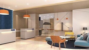 A modern hotel lobby with a reception desk, seating area, and a large window. - Holiday Inn Express Shanghai Tangzhen by IHG (Shanghai)