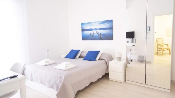 A modern bedroom with a bed, bedside tables, a TV, and a wardrobe. - Casa Viviana - Bari Policlinico (Bari)