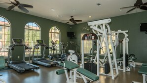 A gym with treadmills, weight machines, and a ceiling fan. - Quiet condo close to Disney World, fully furnished, No Resort Fee (Davenport)