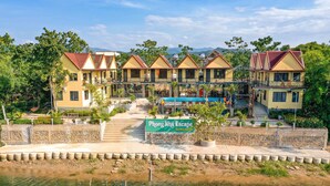 A bungalow-style hotel with multiple buildings, a swimming pool, and a sign reading "Phong Nha Escape Bungalow." - Phong Nha Escape Bungalow (Phong Nha)