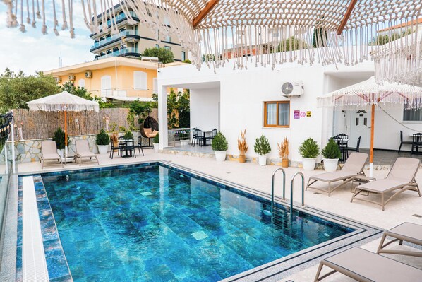 Piscine extérieure en saison, parasols, chaises longues