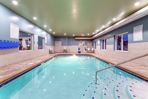 A swimming pool with clear water, surrounded by tiled walls and a ceiling with recessed lighting. - Holiday Inn Express & Suites Columbus - Worthington by IHG (Columbus)