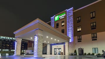 A Holiday Inn Express & Suites hotel with a covered entrance and a stone facade.