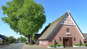 A traditional brick building with a steeply pitched roof and a sign that reads "Hotel".