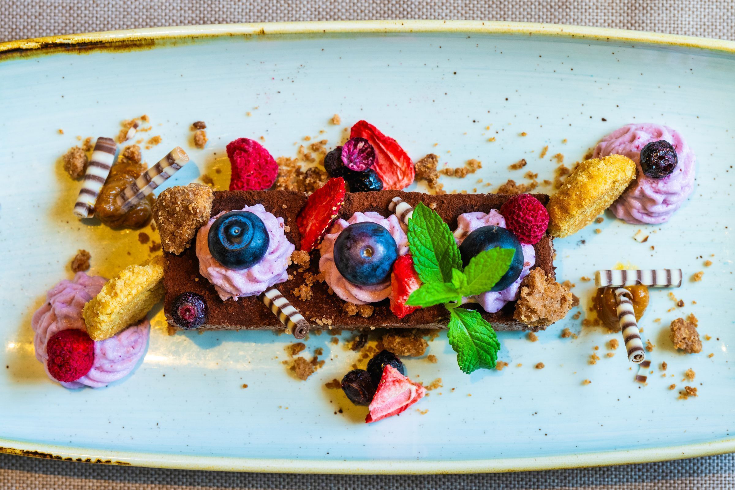 A dessert plate with various fruits and chocolate pieces.