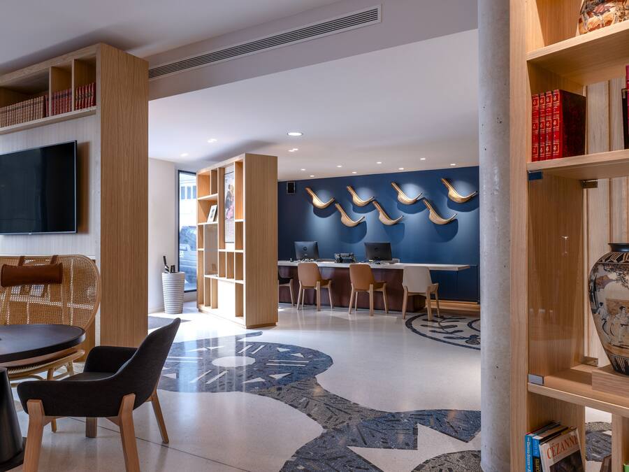 A modern library with bookshelves, a large flat-screen TV, and a decorative vase.