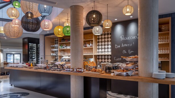 Un área de bufé con diversos alimentos, como pan, pasteles y salsas.