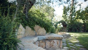 A stone pathway leading through a garden with a stone bench and lush greenery. - Le Balze Charming Apartment with private veranda, 10 min from Perugia Centre (Perugia)