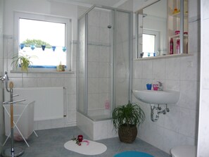 A bathroom with a shower, a sink, a toilet, and a window. - APARTMENT II - PUMMPÄLZHOF (Bad Salzungen)