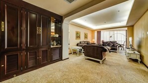 Une chambre d’hôtel avec un grand placard, un ensemble de canapés, une petite table et une lampe.