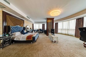 A hotel room with a large bed, a television, a desk, and a balcony with curtains. - Media Hot Spring Hotel (Bazhou)