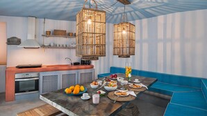 Una cocina moderna con horno empotrado, una mesa de comedor lista para el desayuno y un sofá azul.