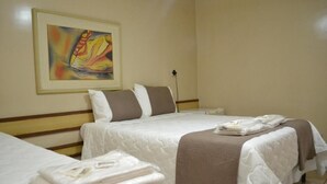 Ein Hotelzimmer mit zwei Betten, einem Bild an der Wand und einem Nachttisch mit Lampe.