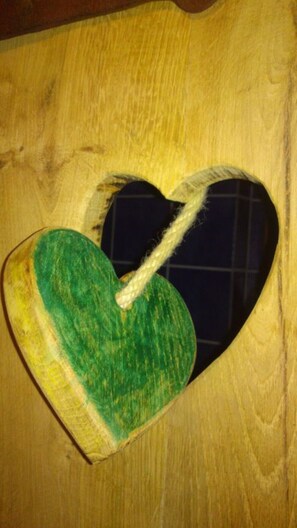 Un cœur en bois découpé, auquel est attachée une corde.