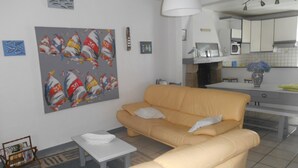 Ein Wohnzimmer mit einer Couch, einem kleinen Tisch und einem Gemälde an der Wand.