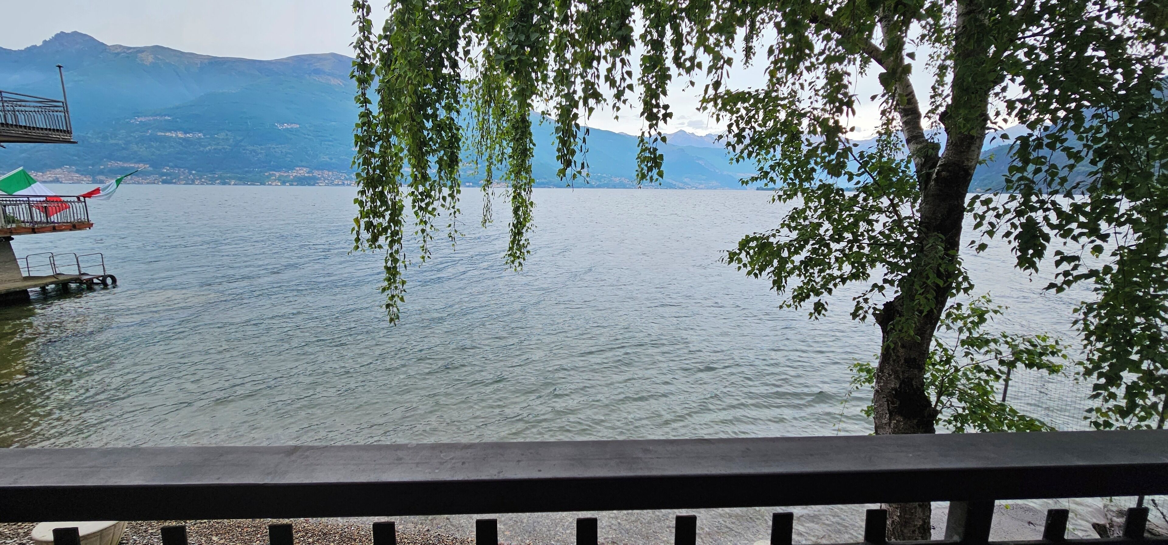 Vista de un lago con un muelle y una bandera.
