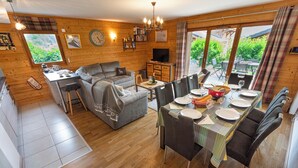 Ein gemütliches Blockhaus mit Essbereich, Küche und Wohnzimmer.