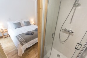 Een bad/douchecombinatie, een haardroger, handdoeken, zeep