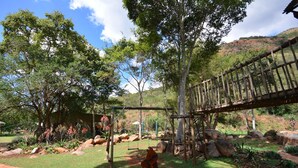 A natural outdoor area with a wooden bridge, swings, and a path. - Rocky Drift Private Nature Reserve (Emgwenya)