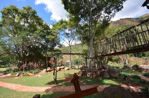 Un espacio natural al aire libre con un puente de madera, columpios y un sendero.