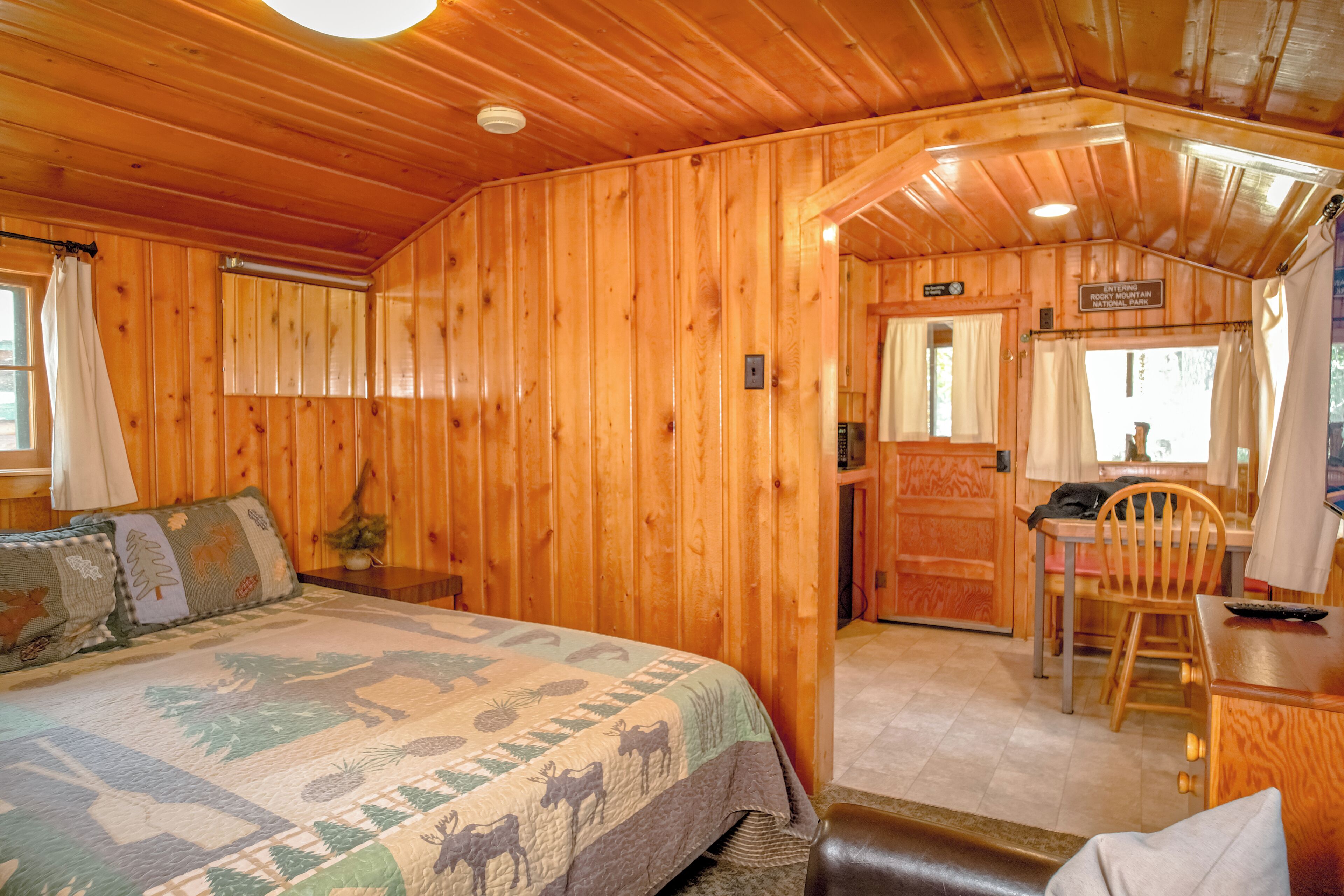 L’intérieur d’une cabane en bois comprend un lit, un coin repas et une salle de bain.