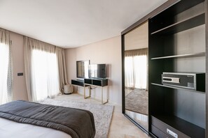 A modern bedroom with a bed, a TV, a dresser, and a large mirror. - AVENUE SUITES APPART HOTEL - STANDARD (Maarif)