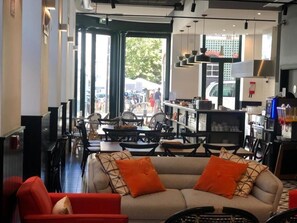 A modern interior with a sofa, dining area, and kitchen visible. - Be Lisbon Hostel Intendente (Lisbon)