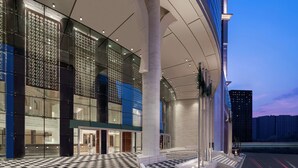 A modern building with a glass facade, large columns, and a patterned floor. - Doubletree by Hilton Jabal Omar Makkah (Makkah)