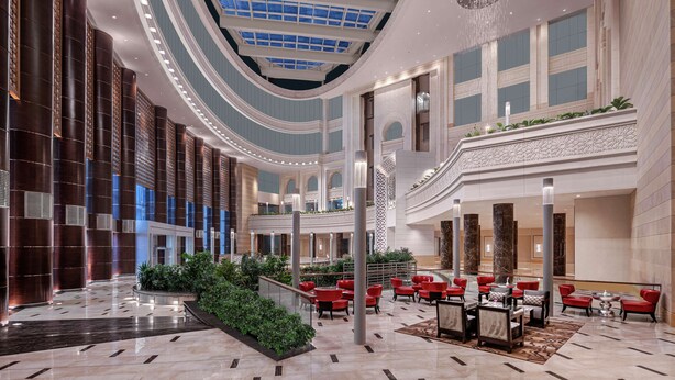 A spacious lobby with a high ceiling, a central atrium, and red seating areas. - Doubletree by Hilton Jabal Omar Makkah (Makkah)