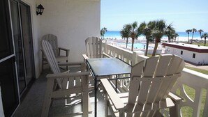 A balcony with a table and chairs, overlooking a pool and beach. - El Matador 338 -  FREE TICKETS!! Your stay includes free tickets to many area attractions! (Fort Walton Beach)
