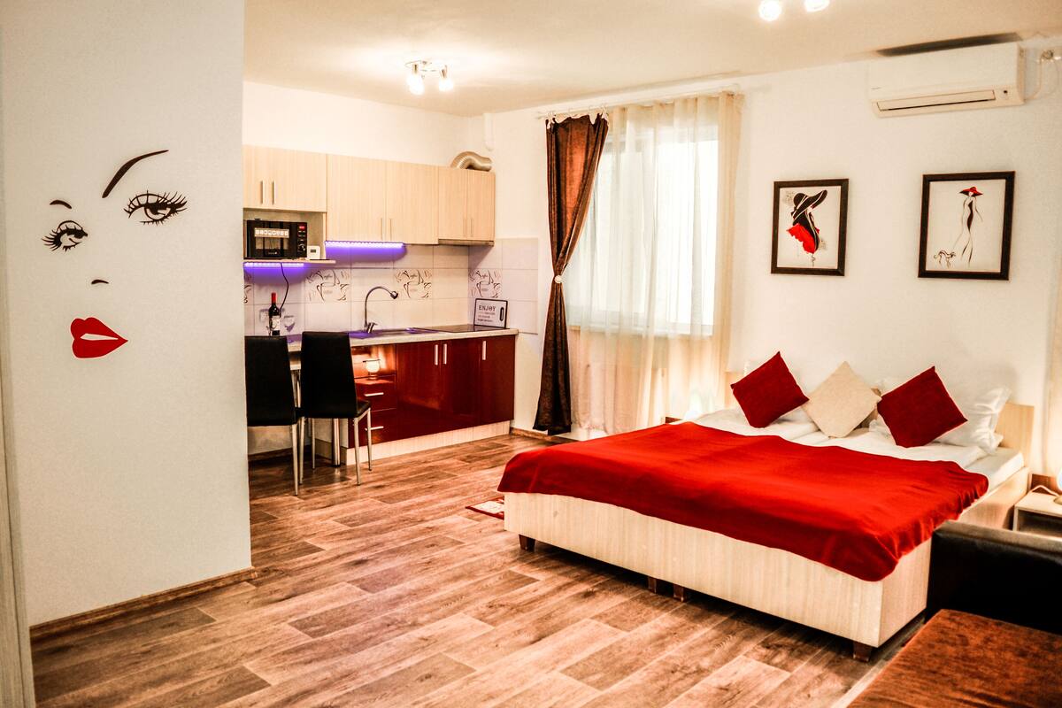 Ein Schlafzimmer mit Bett, Schreibtisch und einer Küchenzeile.