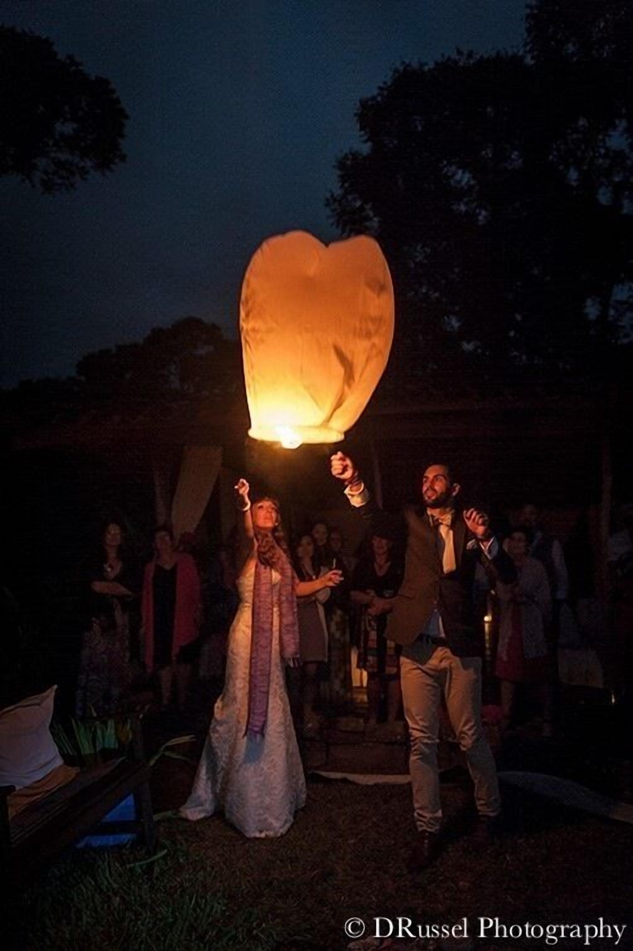 A group of people releasing a heart-shaped lantern.