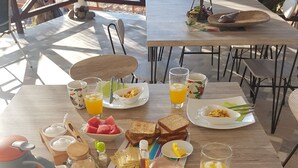 Une table de petit-déjeuner avec divers aliments et boissons, notamment des toasts, des œufs et du jus d’orange.