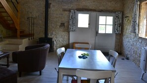 A dining area with a stone wall, a wooden staircase, and a table with chairs. - Couanac, cottage in the countryside with swimming pool (Cayriech)