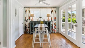 A dining area with a table, chairs, and a ceiling fan.
